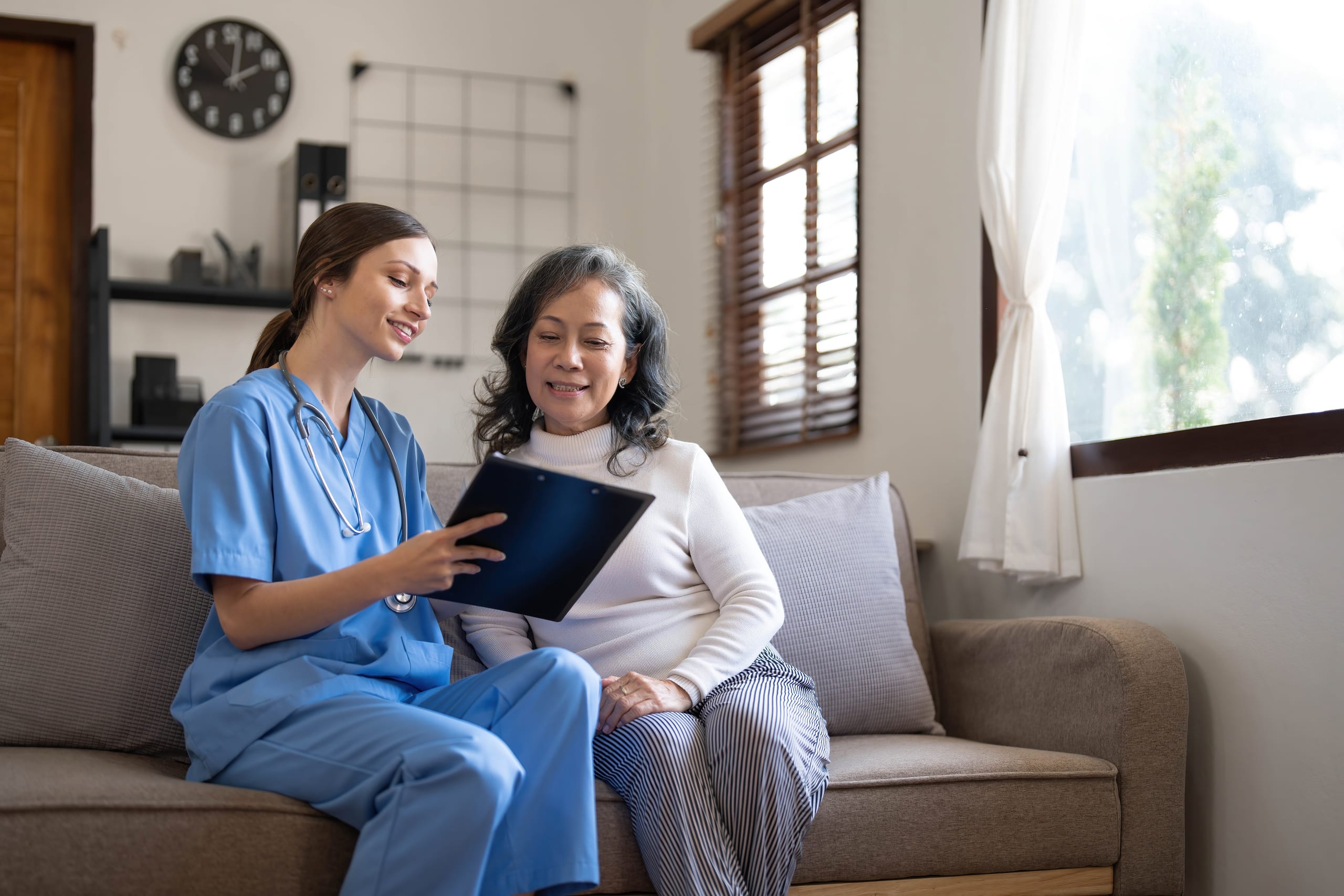 Home health caregiver reviewing a care plan with an older adult at home.